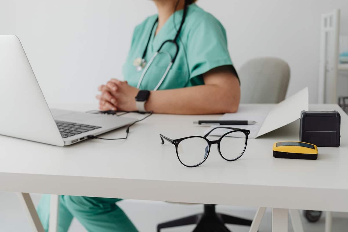 Hospice worker in Blue Scrub Suit Using Macbook Pro