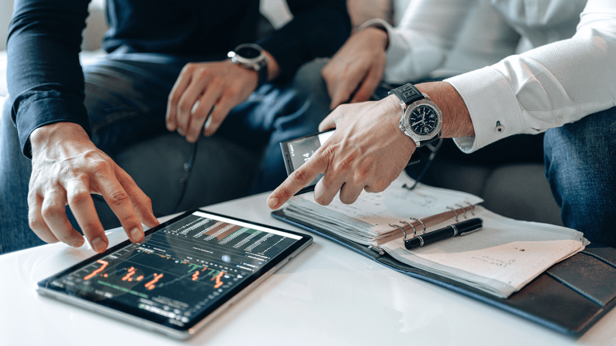 Financial professionals reviewing data on a tablet during a Fin AI Agent customer service strategy discussion
