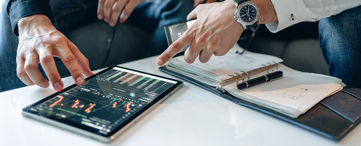 Financial professionals reviewing data on a tablet during a Fin AI Agent customer service strategy discussion