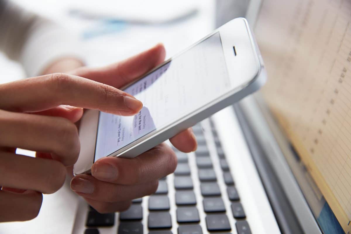 close,up,of,person,at,laptop,using,mobile,phone