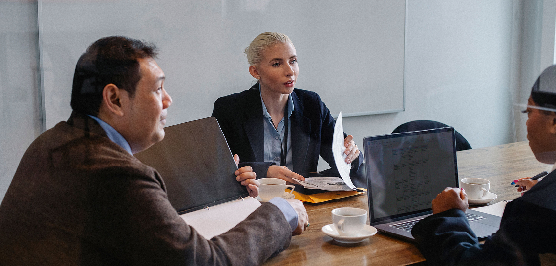 Business professionals discussing AI support and customer service strategies in an office.