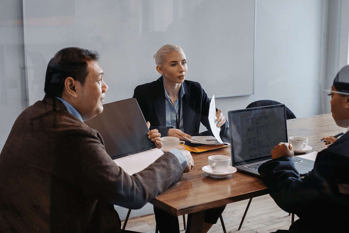Business professionals discussing AI support and customer service strategies in an office.